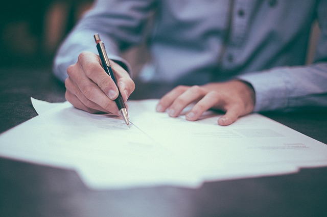 Imagen hombre firmando un contrato.