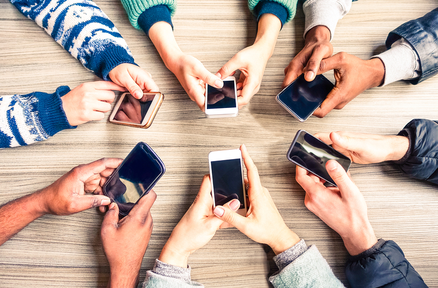 Personas sostenindo sus teléfonos en las manos. Ofrecer un servicio de asistencia a través de WhatsApp.