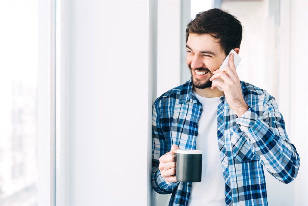 Imagen de hombre hablando sonriendo por teléfono. Incrementar la satisfacción del cliente en tiempos de crisis. 